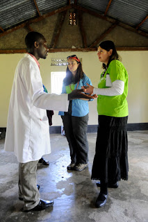 Jennifer Burden of World Moms Blog and Cindy Levin of RESULTS talk to a lab technician in Fort Portal, Uganda, while there with a delegation from the Shot@Life campaign.  Photo credit to Stephanie Geddes.